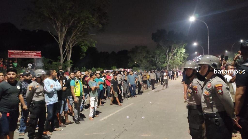 Polisi mengamankan masssa taksi online dan bandara yang bentrok di Bandara Hang Nadim, Sabtu (25/6). 