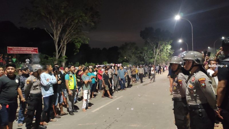 Polisi mengamankan massa taksi online dan bandara yang bentrok di Bandara Hang Nadim, Sabtu (25/6).