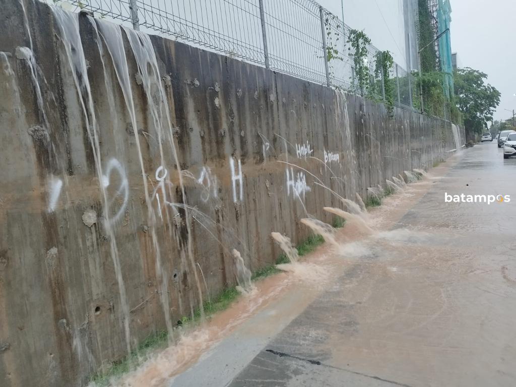 Air drianase dari bangunan Meisterstadt Pollux Habibie membanjiri rumah warga di Perumahan Citra Batam, Selasa (11/7). 