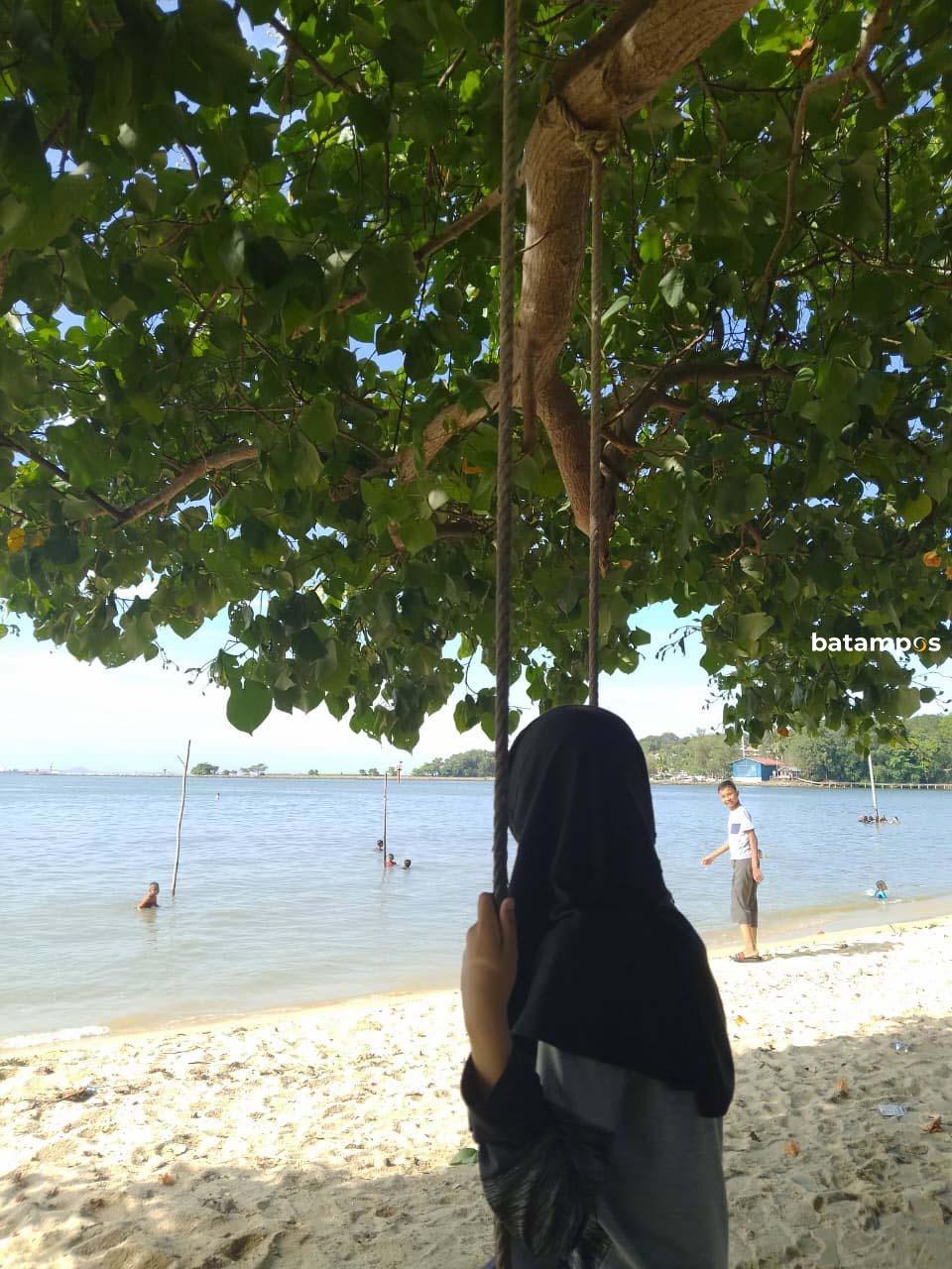 Nasya (diayunan) dan Faris (dikejauhan) bercengkrama di Pantai Nongsa, 18 Mei 2025 lalu. 