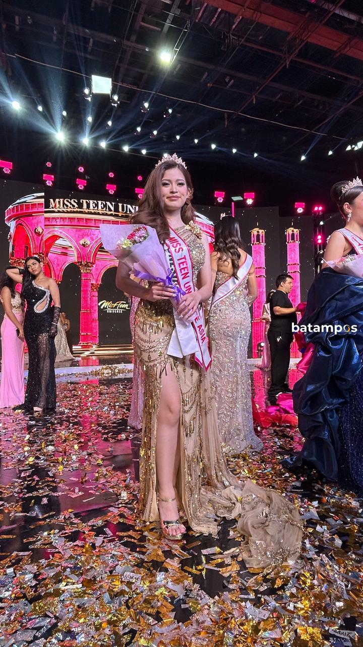 Remaja Batam, Belva Angeline Githa, berdiri anggun di atas panggung Miss Teen Universe 2025 dengan busana tradisional Indonesia berhiaskan detail emas dan ungu.